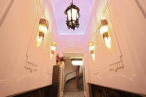 维也纳第七天堂维也纳中心公寓的建筑中带吊灯和楼梯的走廊