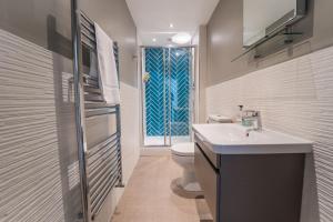 普里茅斯1埃利奥特露台公寓的一间带水槽和卫生间的浴室以及窗户。