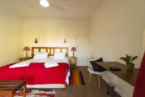 Pongola Game Reserve塔姆波迪住宿加早餐酒店的一间卧室配有红色的床和一张书桌