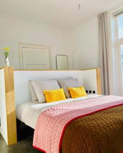 多廷赫姆Villa Wanrooy的一间卧室配有一张带黄色枕头的大床