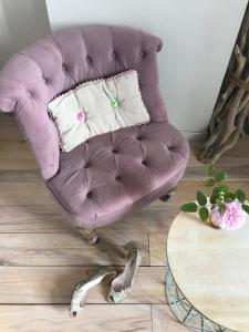 CoursanLe logis blanc bed&breakfast的客厅配有一张桌子,配有一张紫色椅子
