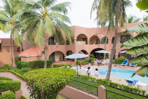 达喀尔Airport Hotel Casino du Cap-vert的享有带游泳池和棕榈树的度假村的景致