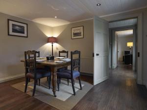 邓韦根Dunvegan Castle Rose Valley Cottage的一间带木桌和椅子的用餐室