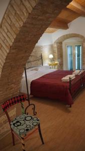 MiglionicoResidenza delle Grazie的一间卧室配有红色的床和椅子