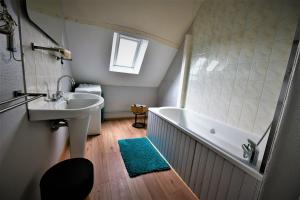 塔登La Vallée du Launay的浴室配有盥洗盆和浴缸。