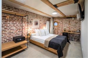 里加瑞克斯韦尔老里加宫酒店的一间卧室设有一张床和砖墙