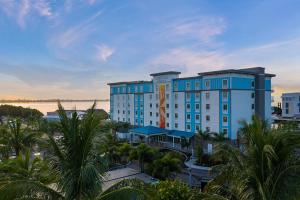 布雷登顿Compass Hotel by Margaritaville Anna Maria Sound的一座大型蓝色建筑,前面有棕榈树