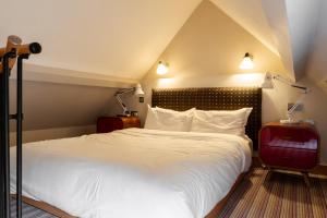 LamberhurstThe Vineyard Lamberhurst的一间卧室配有一张带两盏灯的大型白色床。