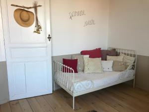 CoursanLe logis blanc bed&breakfast的客房内的一张带枕头的婴儿床