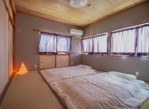 富山Yasuo-shiki Ishigaki-tei #HH5x的一张大床,位于带两个窗户的房间