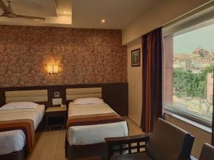 蒂鲁奇奇拉帕利Hotel Deepam的酒店客房设有两张床和窗户。