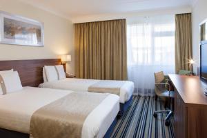 科尔切斯特假日科尔切斯特酒店的酒店客房配有两张床和一张书桌