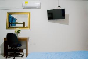 卡塔赫纳Hotel Ocean View的一间卧室配有一张床、一张书桌和一面镜子