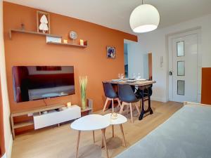 Saint-FonsStop Chez M Select Saga # Qualité # Confort # Simplicité的客厅设有橙色墙壁和餐桌