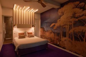 图卢兹安佳丽别墅酒店的一间卧室配有一张壁画床
