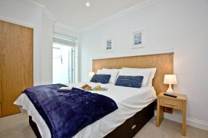 佩恩顿3 Goodrington Lodge, Paignton的白色卧室配有一张大床和一张桌子