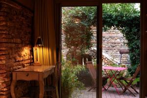 图卢兹安佳丽别墅酒店的客房设有桌子和通往庭院的门。