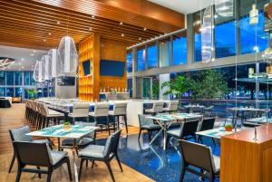 劳德代尔堡Hyatt Centric Las Olas Fort Lauderdale的大楼内带桌椅的餐厅