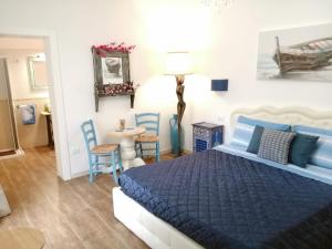 圣维托诺曼Borgo Salentino的一间卧室配有蓝色的床和桌椅