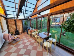 NarewkaStajnia Bukwica的温室配有桌椅和窗户。