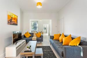 诺丁汉Jasmine Villa A - Ideal for QMC & Uni - Free parking的客厅配有2张蓝色沙发和黄色枕头