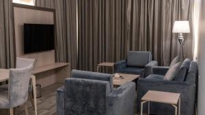 塔伊夫سفن جاردنز وادي وج的客厅配有蓝色椅子和电视