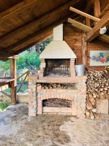 圣焦万尼因菲奥雷Casa della Montagna - Baita delle Rondini的一堆木头的室外砖炉