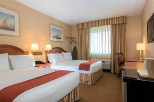 LawrenceFive Towns Inn - JFK Airport的酒店客房设有两张床和窗户。