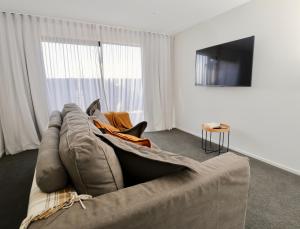 蒂阿瑙Lake House - Te Anau Holiday Home的带沙发和电视的客厅