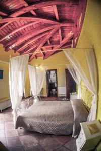 切普拉诺Agriturismo ciociaro " il colle " HOTEL RISTORANTE的卧室配有一张带白色窗帘的大床