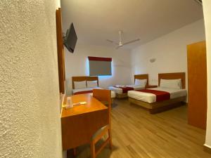 曼萨尼约Hotel LB的酒店客房设有两张床和一张桌子。