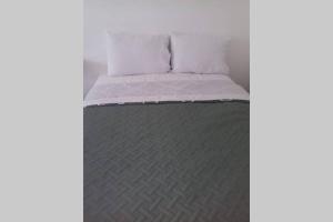 科苏梅尔Studio Loft Cozumel的一张带白色床单和灰色毯子的床