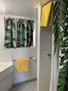 SarinaSandpiper Motel的浴室设有黄色的淋浴帘和水槽