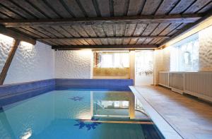 迈尔霍芬Aparthotel Landhaus St. Joseph (Indoor Pool)的一座带木制天花板的别墅内的游泳池