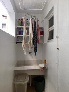 瓜鲁雅Apartamento PRAIA do TOMBO - Guarujá的一间带卫生间的浴室和一个带连接架的架子