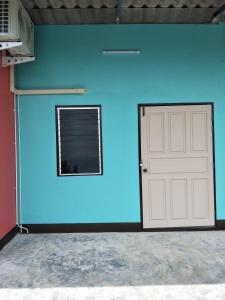 Ban Bang Rin (1)Home hug villa的一面带车库门和窗户的蓝色墙壁