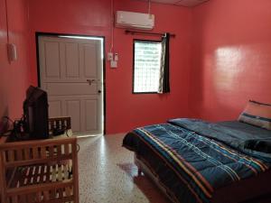 Ban Bang Rin (1)Home hug villa的卧室设有红色的墙壁、一张床和一扇门