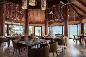 拉迈Pavilion Samui Villas and Resort - SHA Extra Plus的餐厅设有桌椅和窗户。