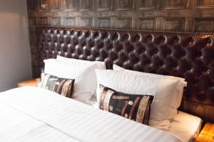 加拉希尔斯鲑鱼宾馆的一间卧室配有一张带皮革床头板和枕头的床。