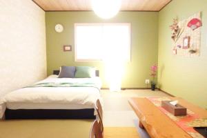 京都Fukenouchi House的一间卧室设有一张床、一个窗口和一张桌子