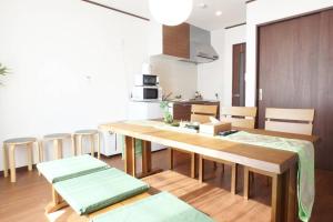 京都Fukenouchi House的厨房以及带木桌和椅子的用餐室。