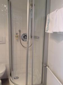 巴特维塞玛格丽特酒店的浴室里设有玻璃门淋浴