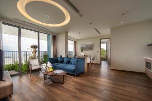 吉婆岛Flamingo Premium Cat Ba Beach Resort的客厅配有蓝色的沙发和桌子