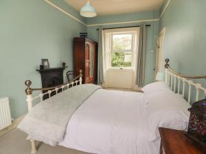 基尔基Newtown East的一间卧室配有一张带白色床单的床和一扇窗户。