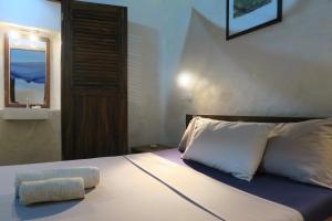 莫桑比克岛Cafe Central的一间卧室配有一张带枕头和镜子的床