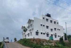 SivasamudramKSTDC Hotel Mayura Bharachukki, Shivanasamudra的道路一侧的白色建筑