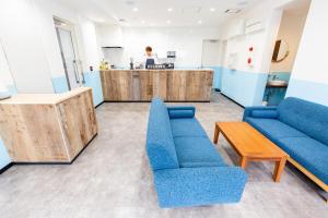 东京Port House Hatsudai的客厅配有蓝色的沙发和台面