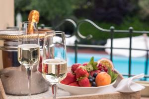 米萨诺阿德里亚蒂科吉拉索利1号客栈的一张桌子,上面放着两杯葡萄酒和一碗水果