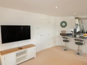 博德明Stores & Supplies的白色的厨房设有壁挂式平面电视。