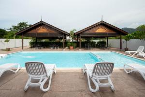 瓜埠Riverra Inn Langkawi的一个带两把椅子和一张桌子的游泳池